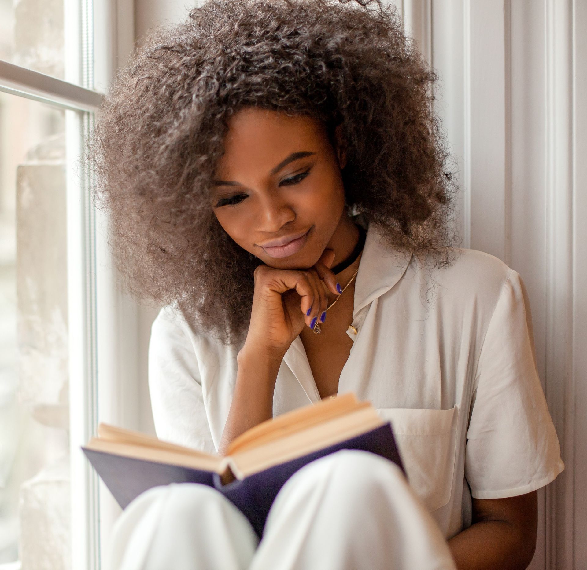 A Boy Reading a Book while Listening to Music