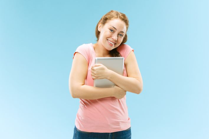 Smiling Woman in Black and Yellow Long Sleeve Shirt Holding Blue Book